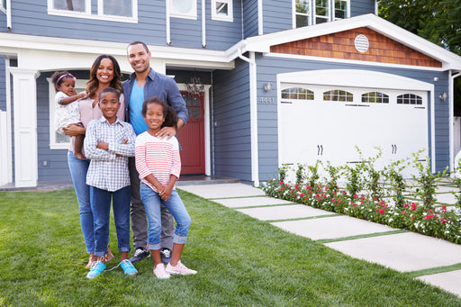 a happy family standing in front of their house and garage