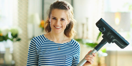 A woman using her hoover to get rid of the last of the moth infestation in her home.