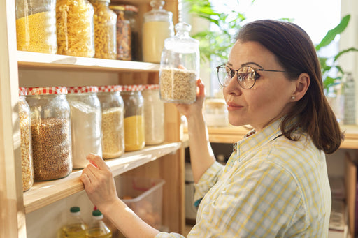 woman with shelves full of dried foodstuffs in sealed containers