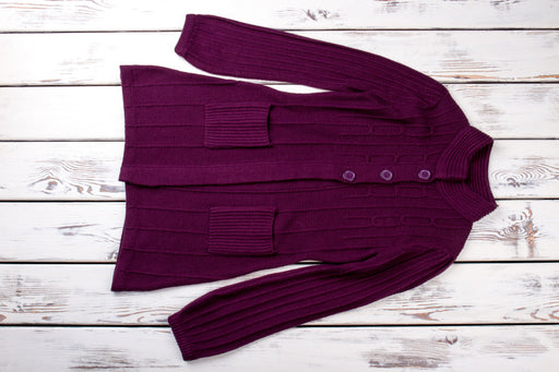 a dark purple coloured cardigan lying flat