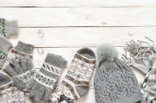 a selection of woollen gloves, socks and a bobble hat