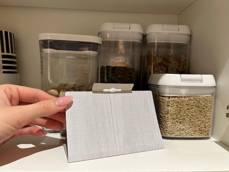 a MothPrevention Pantry Moth Trap placed on a shelf amongst dried food in sealed containers