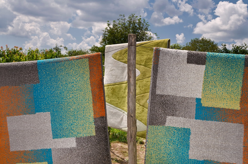 rugs and blankets airing on a line outdoors