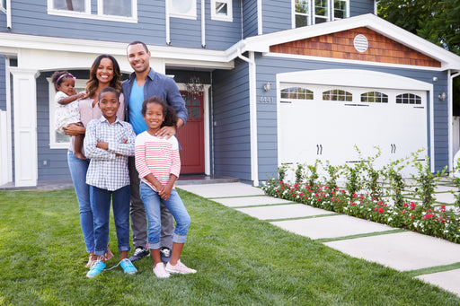 a happy family standing in front of their house and garage