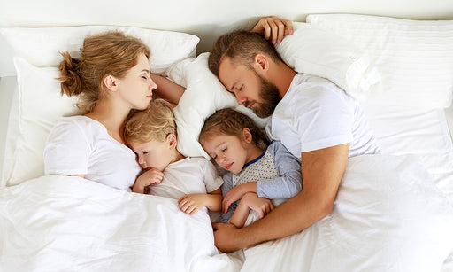 a sleeping family in bed