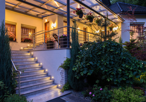 a welcoming home entrance and balcony lit up at night