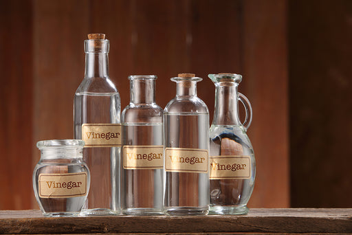 a collection of different shaped bottles containing white vinegar