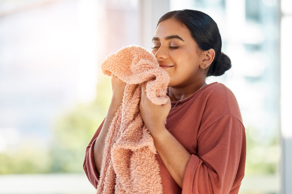 a woman taking in the smell of her fresh clean laundry