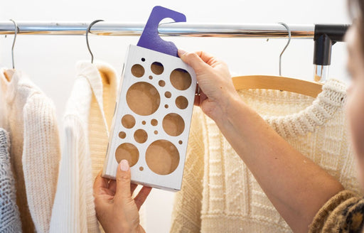 a MothPrevention Clothes Moth Trap being placed among woollen garments