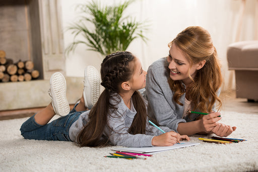 a smiling mother and daughter enjoying time together on their living room carpet