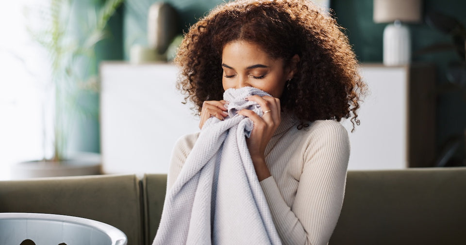 a woman smelling her clean laundry