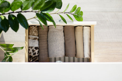 neatly folded sweaters in a drawer