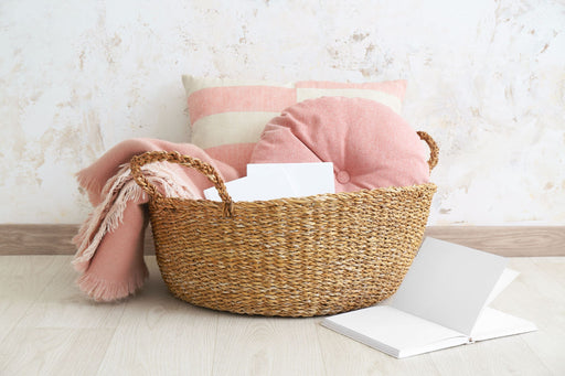 a wicker basket filled with cushions and a blanket