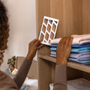 Woman placing a clothes moth trap on a shelf