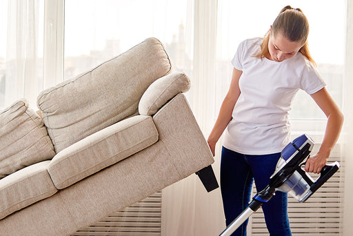 the area under a couch being vacuumed thoroughly