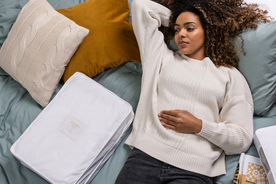 a woman lying on her bed next to a cotton storage bag