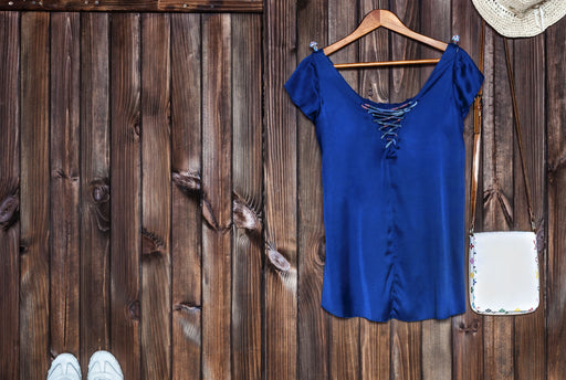 a bright blue silk blouse on a hanger