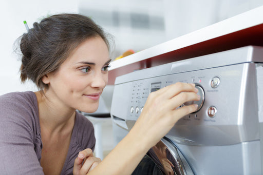 woman choosing the temperature for her machine wash