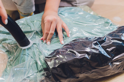 clothing being vacuum sealed into a storage bag